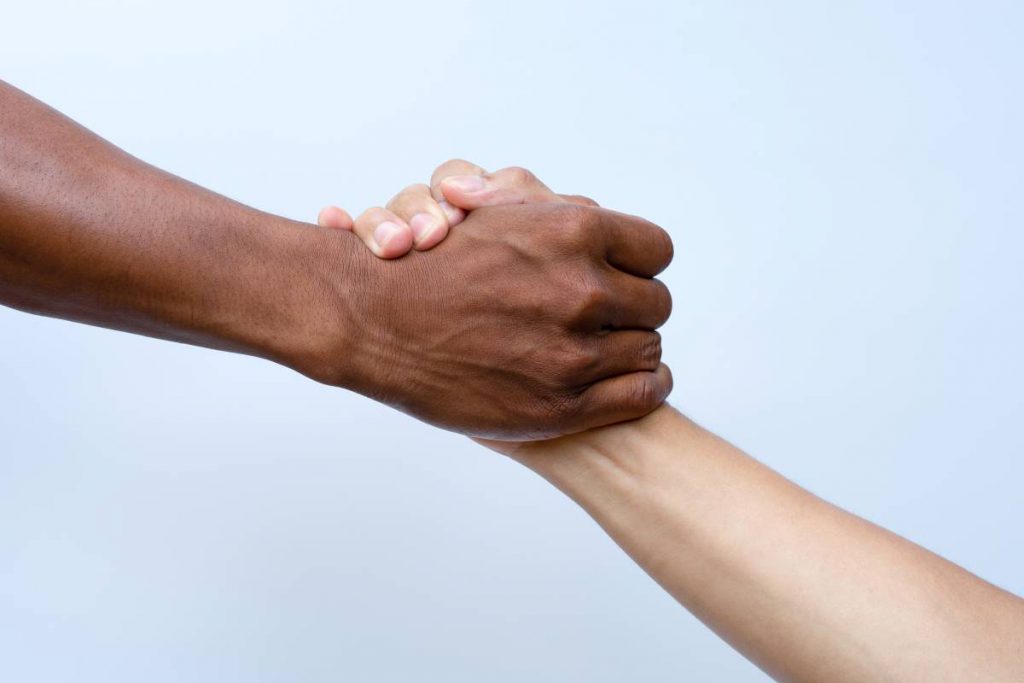 Duas mãos de diferentes em um aperto de mão, representando a solidariedade.