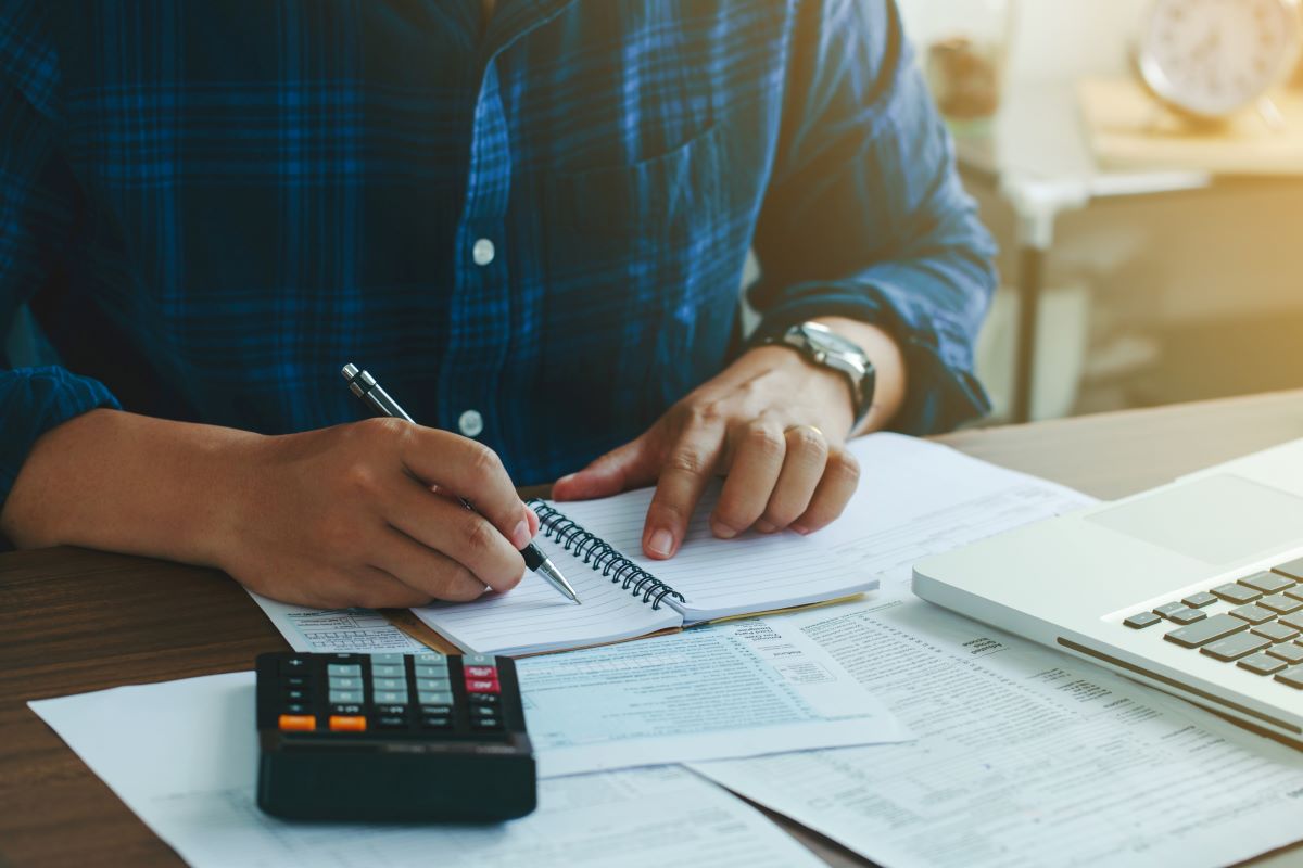 Um homem usando uma calculadora para verificar quanto IRS ele tem que pagar.